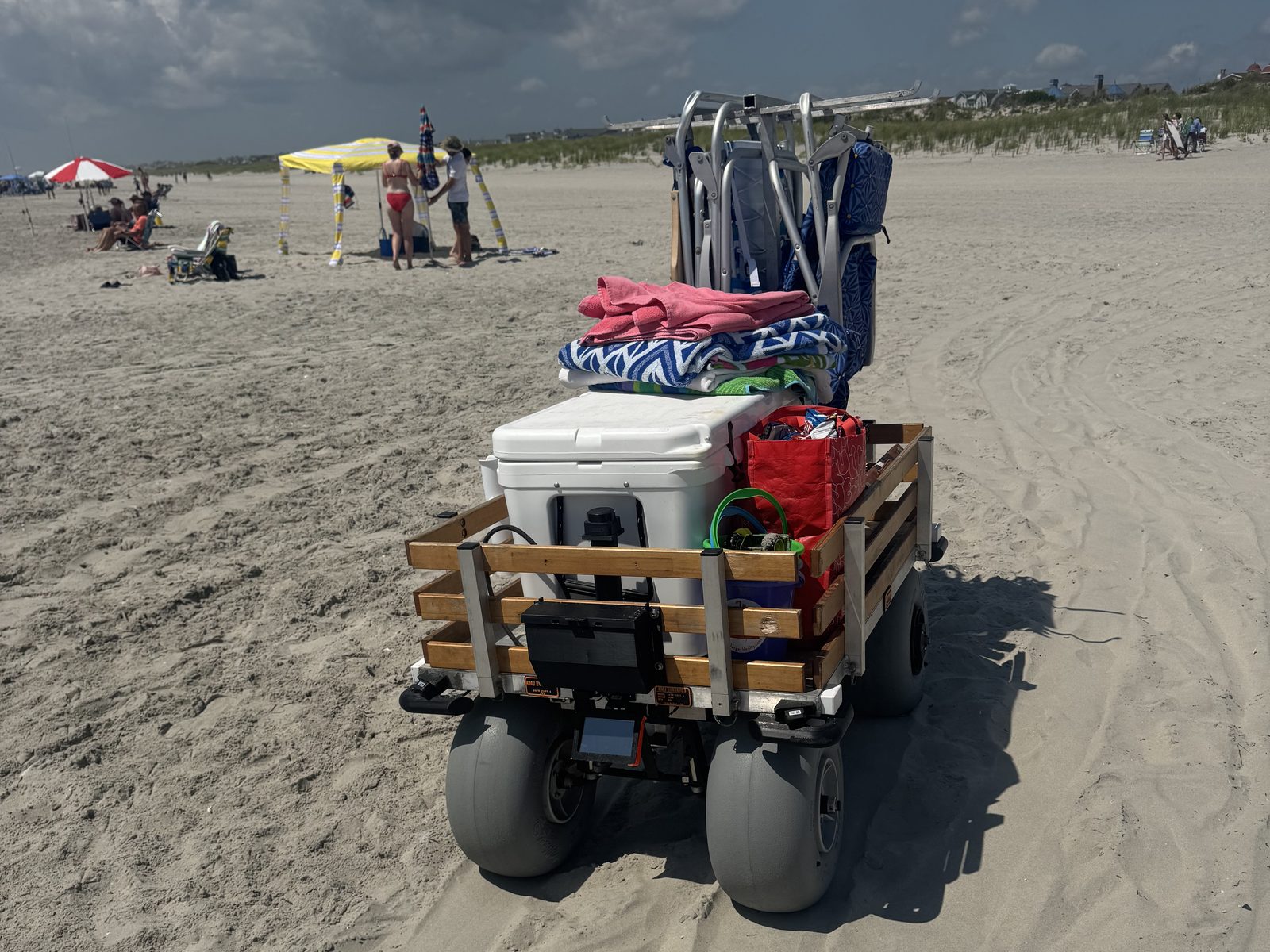 Rear view with fresh tire tracks in the sand, drive electronics tucked under the loaded bed
