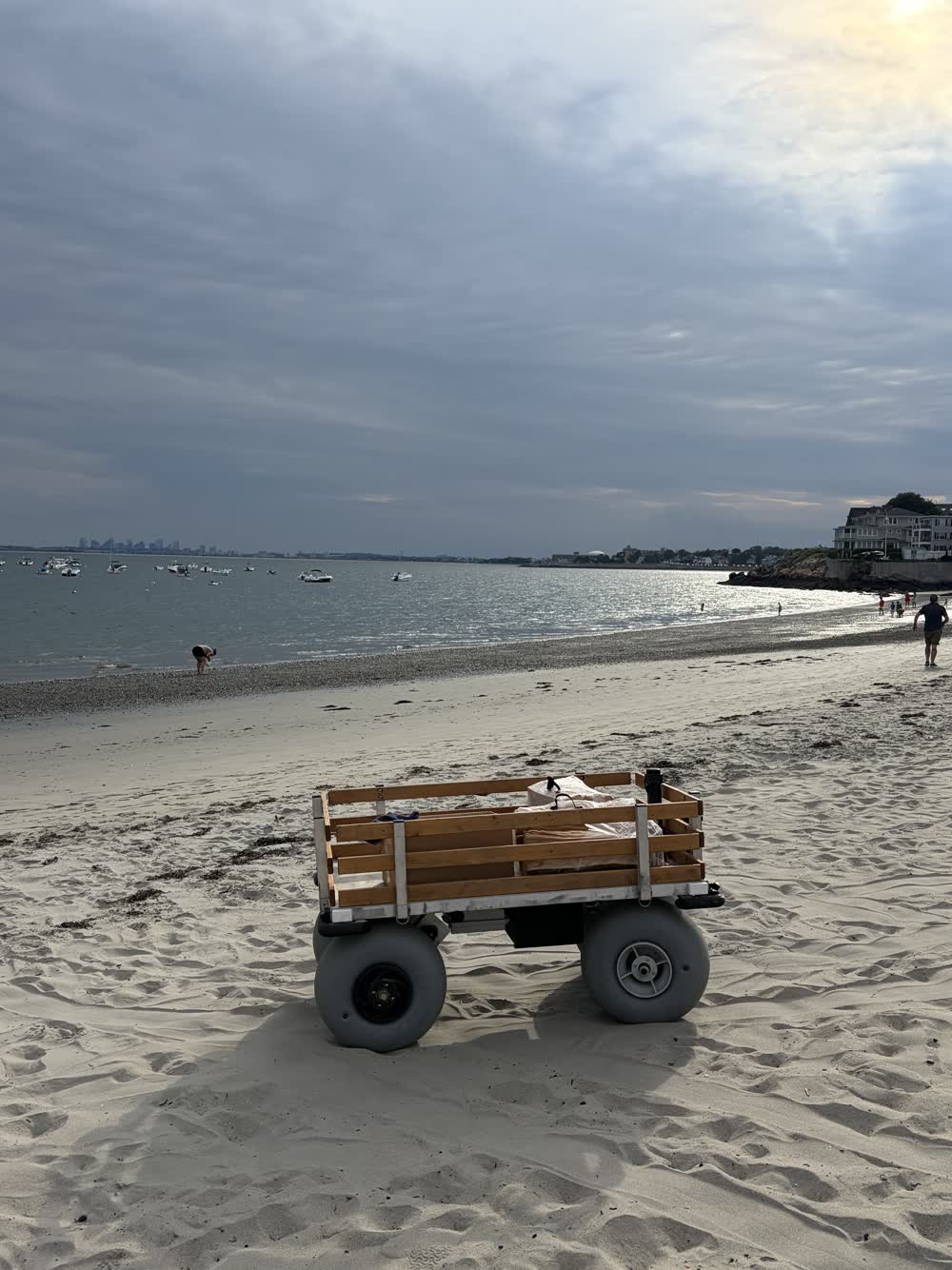 The cart alone on an empty evening beach, the city skyline far across the water