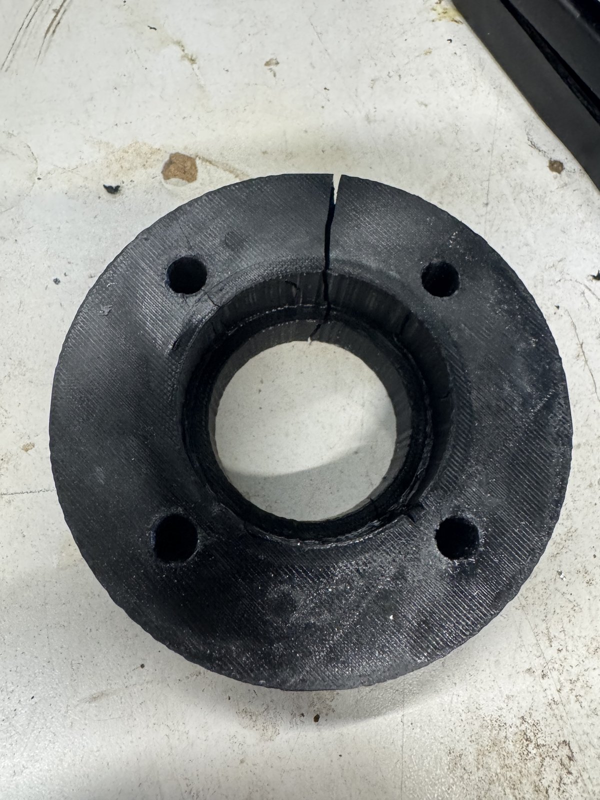 The old PETG wheel spacer cracked clean through by drive torque